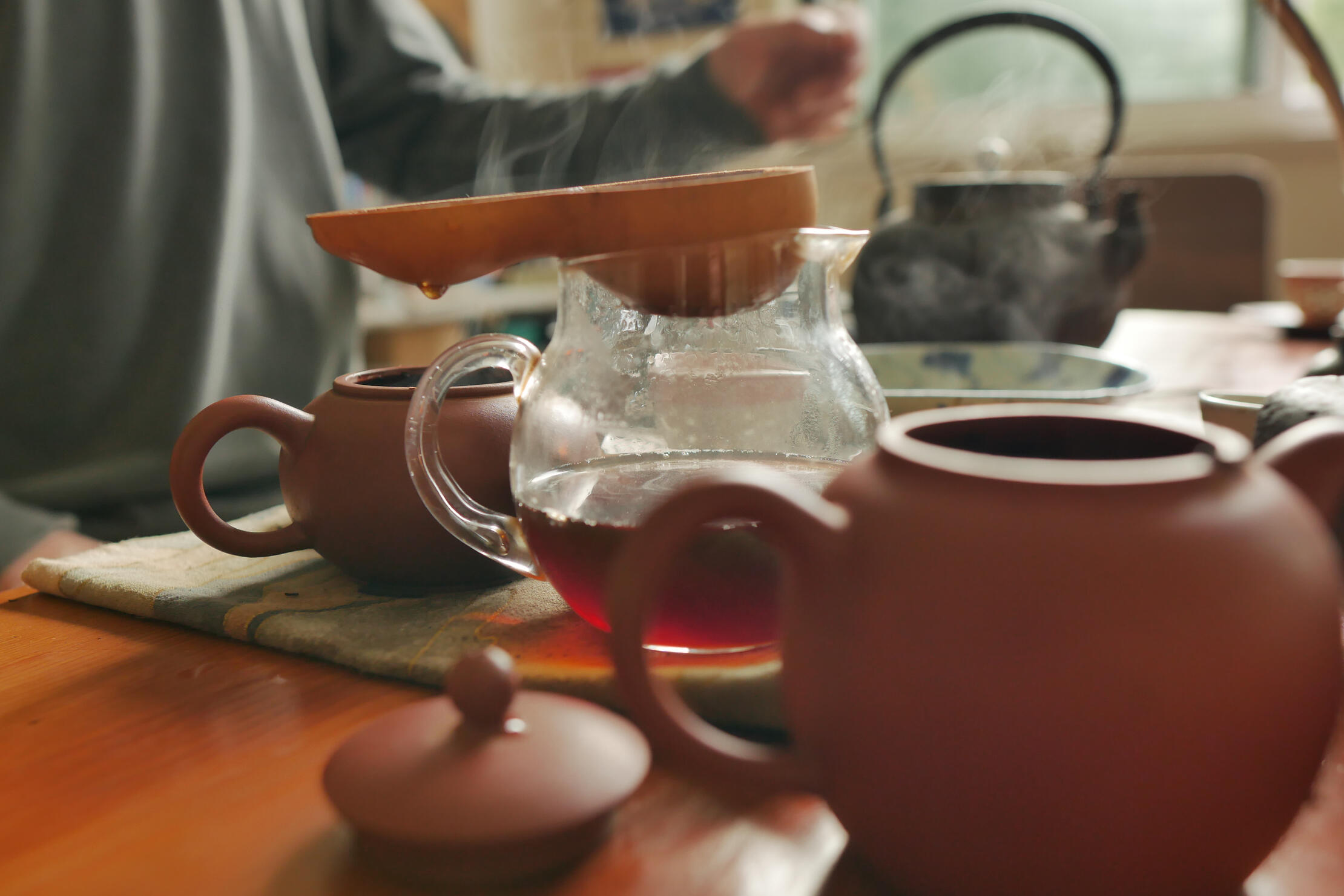 Gong Fu Cha Puerh Tea Ceremony 1 Gong Fu Cha Puerh Tea Ceremony - tea drips into glass beaker from steaming strainer